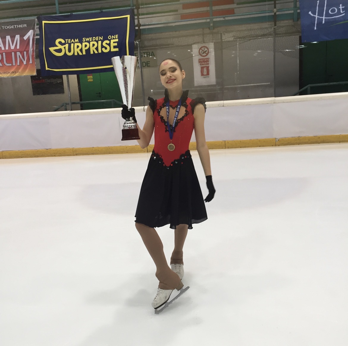 Sabina Kosimova holding a trophy after a figure skating competition